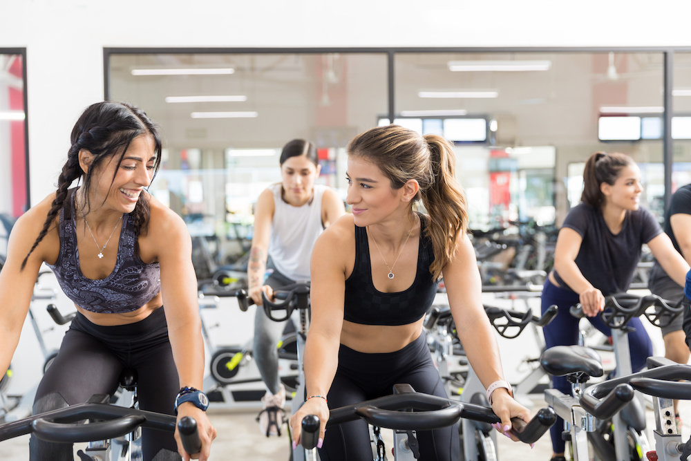 Women Communicating While Riding Stationary Bikes